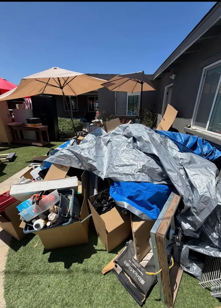 Large pile of boxes and tarps on a lawn ready to be loaded